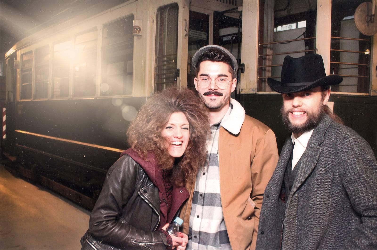 Drei Menschen vor einem Zug.